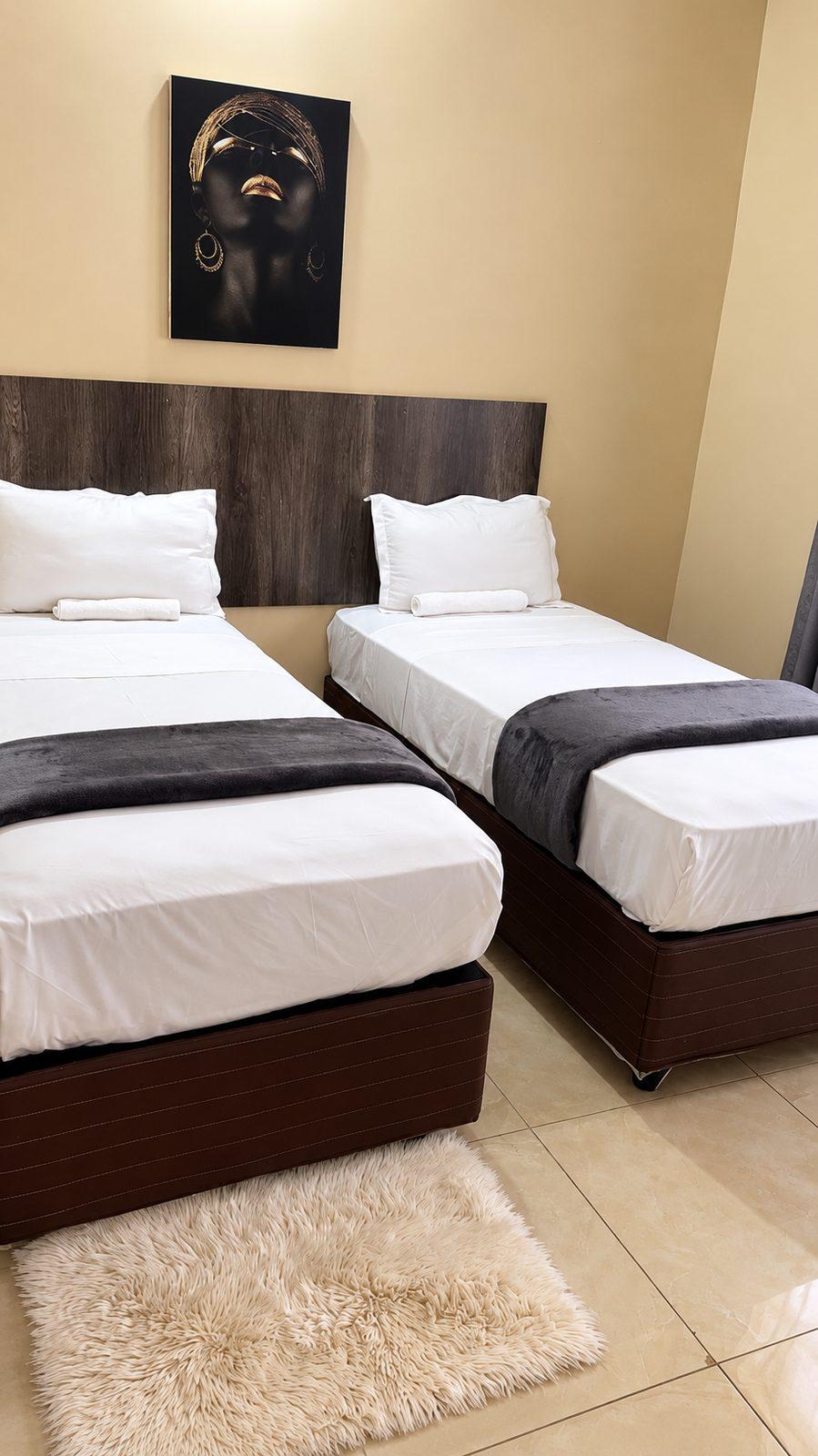 Twin bed arrangement in a standard room at Fallsview Guest House, with two single beds made up in white linen